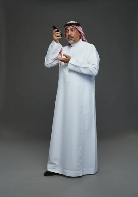 رجل سعودي مسن يتحدث بالهاتف في استوديو
