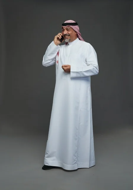 رجل سعودي مسن يبتسم أثناء التحدث في الهاتف