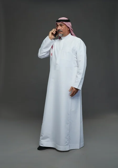 Senior Saudi Man in Traditional Thobe Calling on Smartphone