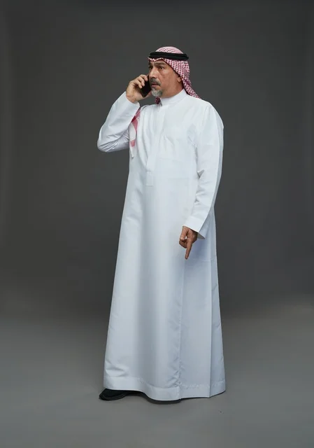 رجل سعودي يتحدث عبر الهاتف المحمول في استوديو