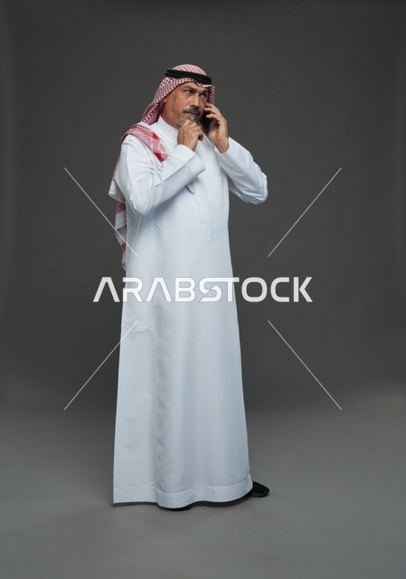 رجل سعودي مسن يتحدث بالهاتف المحمول في استوديو