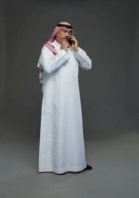 رجل سعودي مسن يتحدث بالهاتف المحمول في استوديو