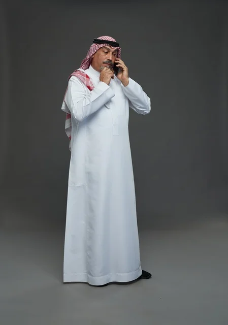 رجل سعودي مسن يتحدث بالهاتف في استوديو