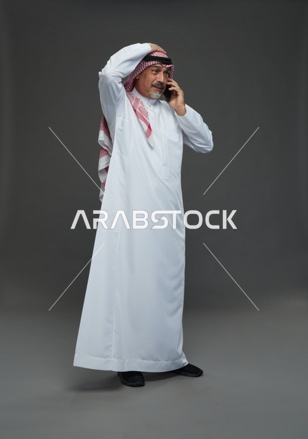 رجل سعودي مسن يتحدث بالهاتف في الاستوديو