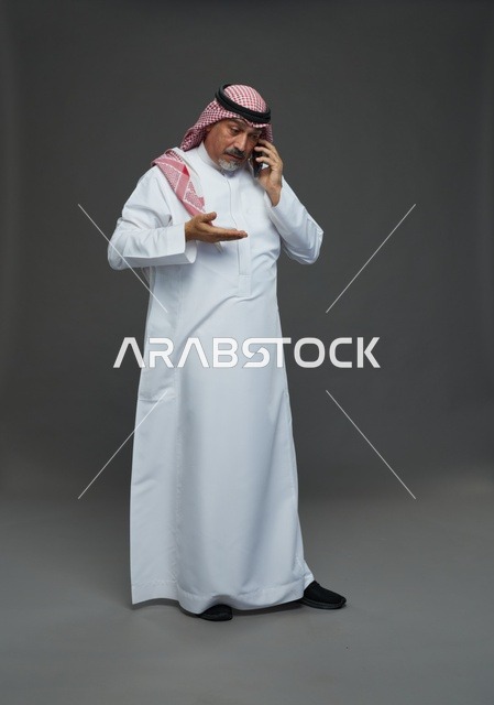 رجل سعودي مسن يتحدث بالهاتف في استوديو