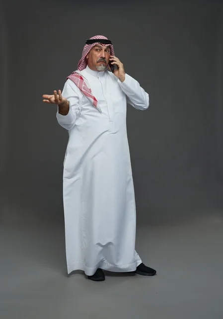 رجل سعودي مسن يتحدث بالهاتف في استوديو