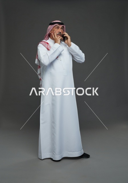 رجل سعودي مسن يتحدث بالهاتف المحمول