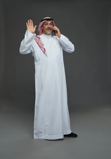 Elderly Saudi Man Talking on Smartphone and Waving