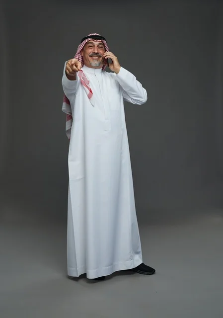 Senior Saudi Man Talking on Phone and Pointing