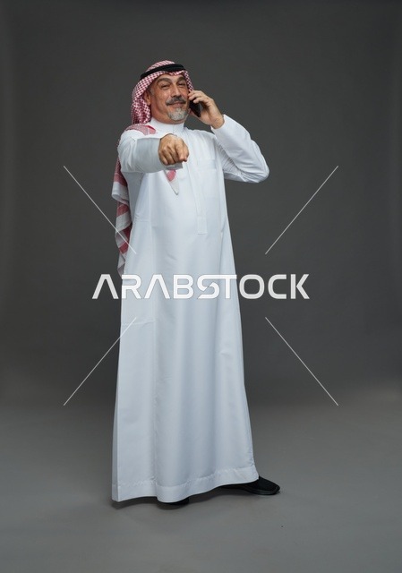 Elderly Saudi man smiling while talking on the phone