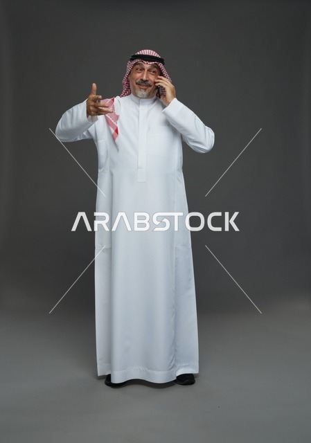 رجل سعودي مسن يتحدث في الهاتف المحمول