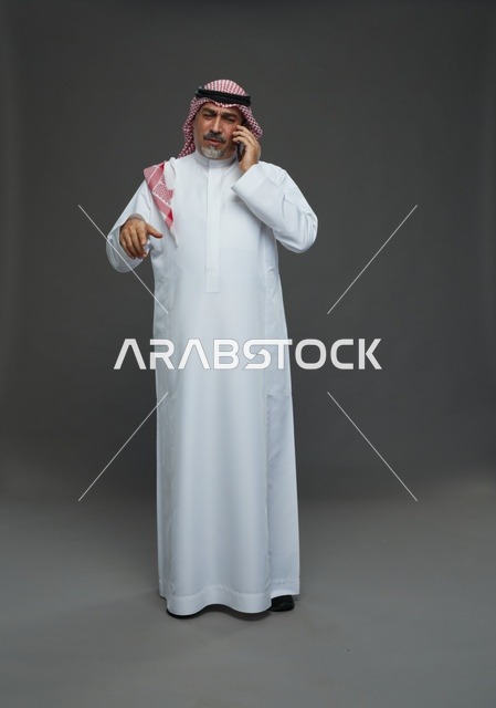 رجل سعودي مسن يتحدث في الهاتف المحمول