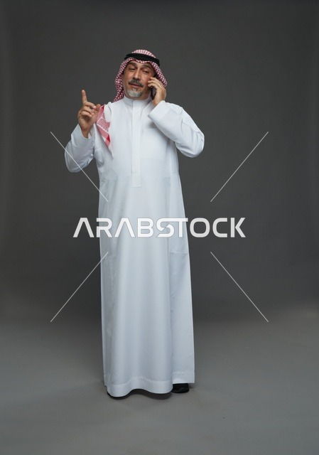 رجل سعودي مسن يتحدث بالهاتف في استوديو