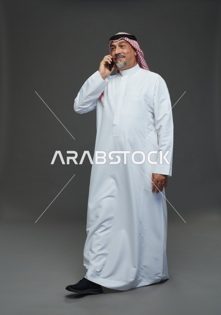 رجل سعودي مسن يتحدث بالهاتف في الاستوديو