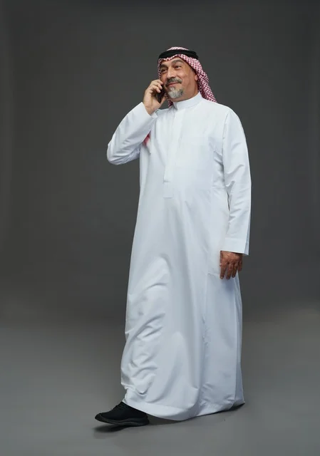 رجل سعودي مسن يتحدث بالهاتف في الاستوديو