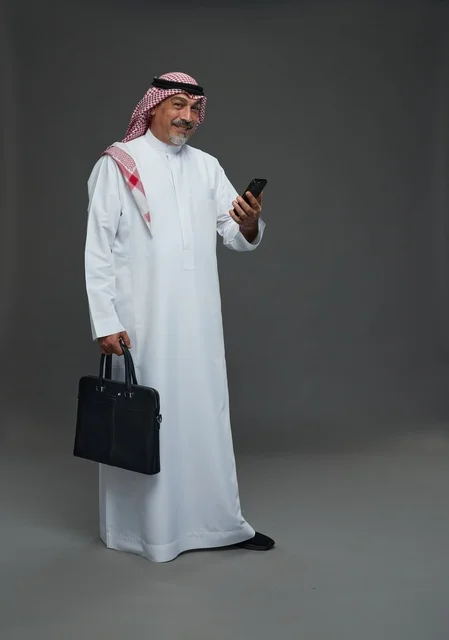 Elderly Saudi Businessman Holding Smartphone and Briefcase