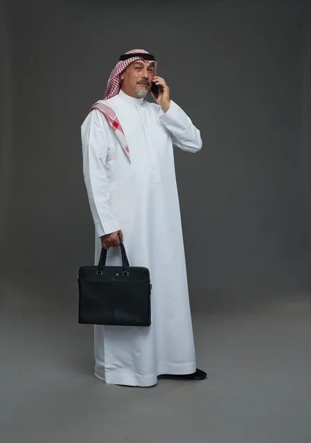 Saudi Businessman with Briefcase Talking on Phone Studio