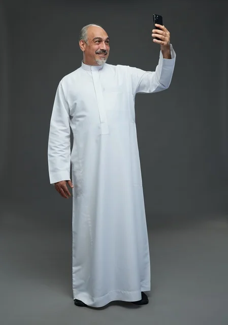 Senior Saudi Man in White Thobe Taking Smartphone Selfie