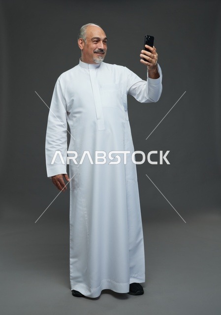 Senior Saudi Man Using Smartphone in Studio