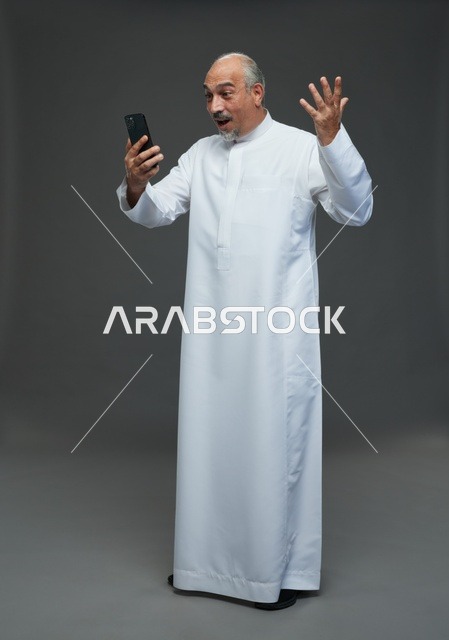 Elderly Saudi Man Using Smartphone on Grey Background