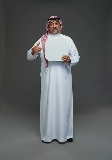 رجل سعودي مسن يحمل لوحة إعلانية فارغة