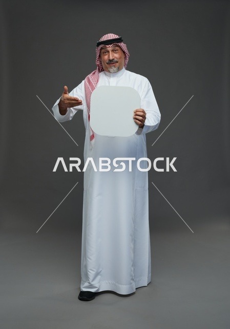 رجل سعودي مسن يحمل لوحة إعلانية فارغة في استوديو
