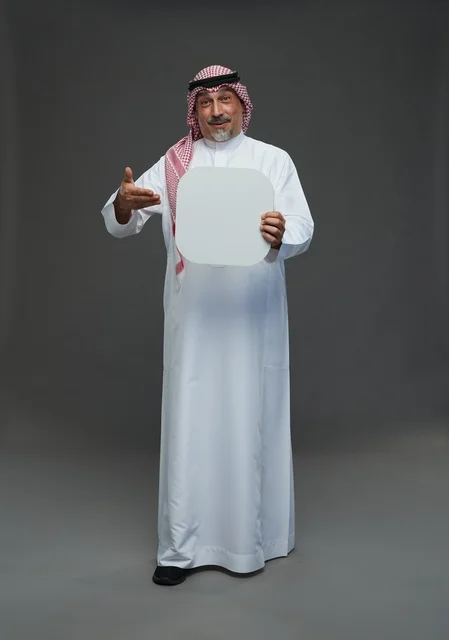رجل سعودي مسن يحمل لوحة إعلانية فارغة في استوديو