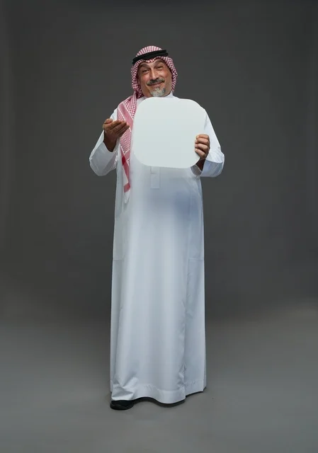 رجل سعودي مسن يحمل لوحة إعلانية بيضاء فارغة