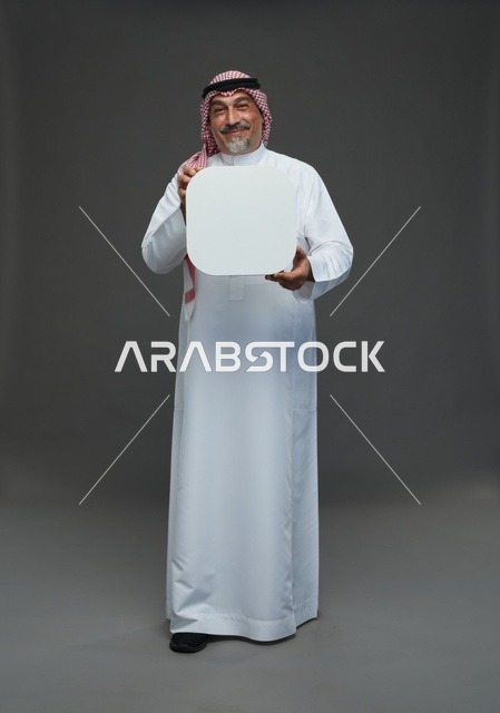 رجل سعودي مسن يحمل لوحة إعلانية بيضاء فارغة