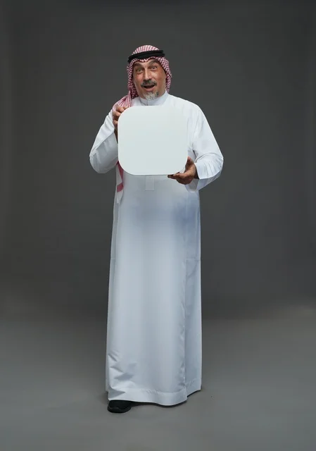 رجل سعودي مسن يحمل لوحة إعلانية فارغة