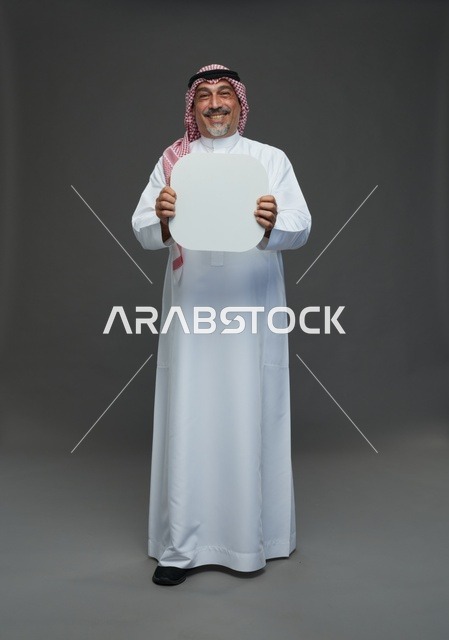 رجل سعودي مسن يحمل لوحة إعلانية بيضاء فارغة