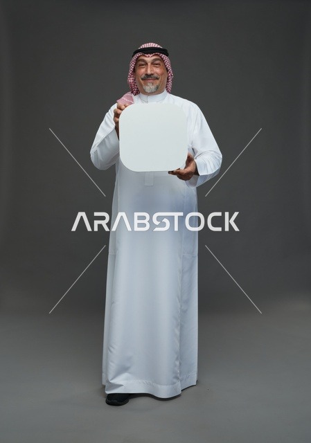 رجل سعودي مسن يحمل لوحة إعلانية فارغة في استوديو