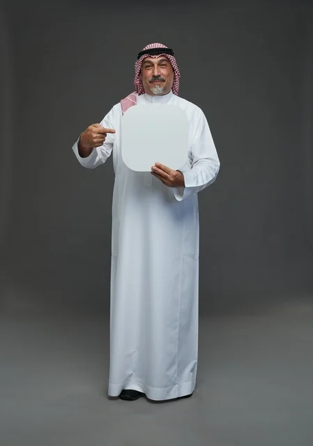 رجل سعودي مسن يحمل لوحة إعلانية بيضاء فارغة