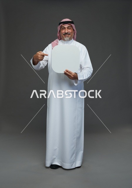 رجل سعودي مسن يحمل لوحة إعلانية بيضاء فارغة