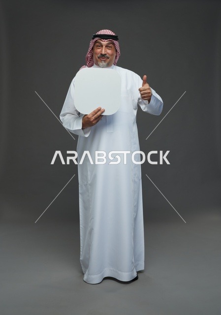 رجل سعودي مسن يحمل لوحة بيضاء فارغة