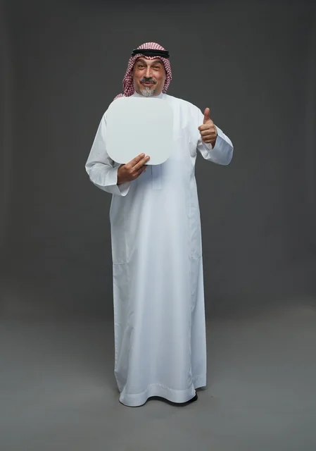 رجل سعودي مسن يحمل لوحة بيضاء فارغة