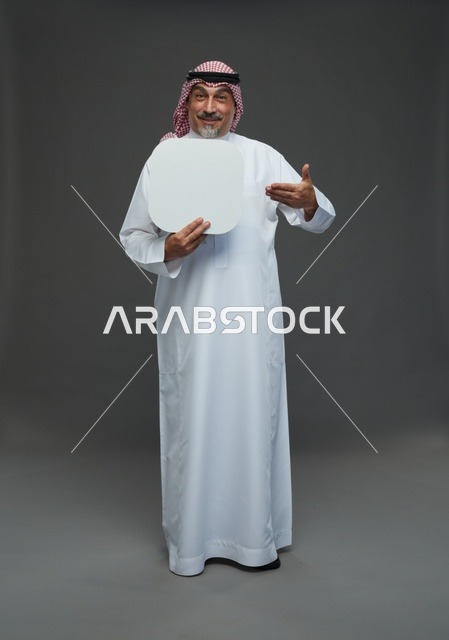 رجل سعودي مسن يحمل لوحة إعلانية بيضاء فارغة