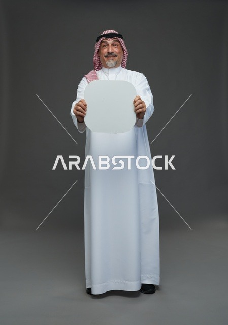 رجل سعودي مسن يحمل لوحة إعلانية بيضاء فارغة