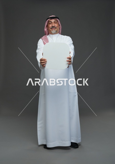 رجل سعودي مسن يحمل لوحة إعلانية بيضاء فارغة