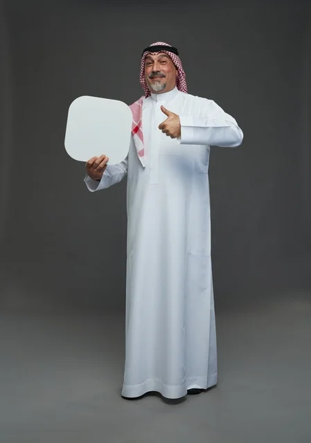 رجل سعودي مسن يحمل لوحة إعلانية فارغة