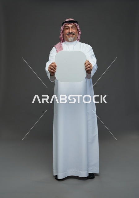 رجل سعودي مسن يحمل لوحة إعلانية بيضاء فارغة