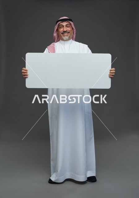 رجل سعودي مسن يحمل لوحة إعلانية فارغة
