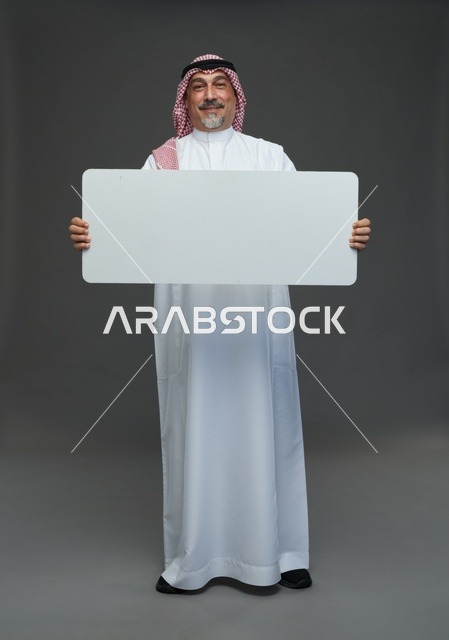 رجل سعودي مسن يحمل لوحة إعلانية بيضاء فارغة