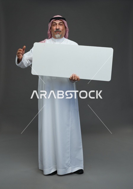 رجل سعودي مسن يحمل لوحة إعلانية بيضاء فارغة