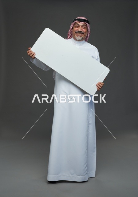 رجل سعودي مسن يحمل لوحة إعلانية بيضاء فارغة