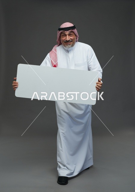 رجل سعودي مسن يحمل لوحة إعلانية بيضاء فارغة