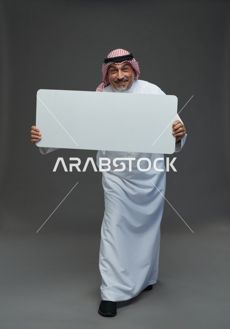 رجل سعودي مسن يحمل لوحة إعلانية فارغة