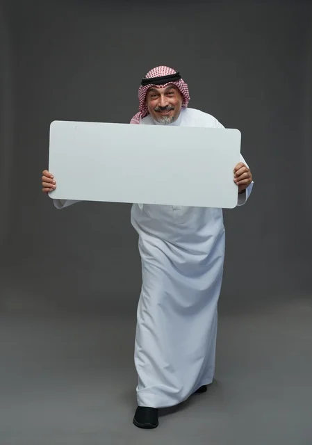 رجل سعودي مسن يحمل لوحة إعلانية فارغة