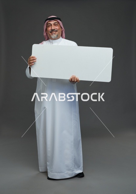 رجل سعودي مسن يحمل لوحة إعلانية فارغة