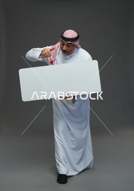 رجل سعودي مسن مع لوحة إعلانية فارغة وعلامة إعجاب
